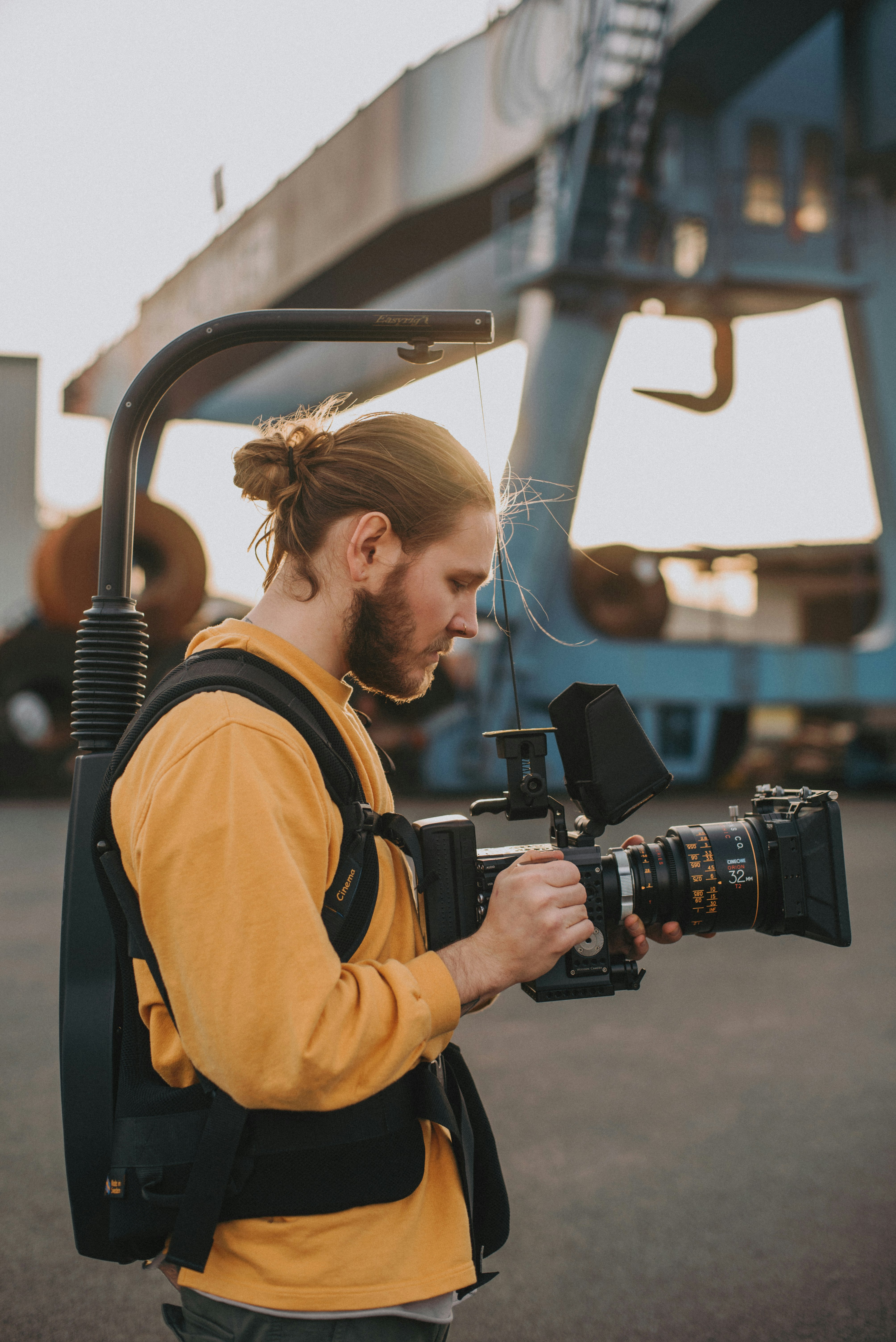 man in yellow jacket holding black dslr camera